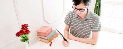 丁寧に字を書く男性