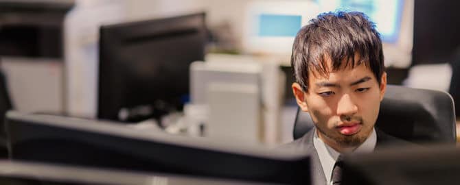 PCが並ぶオフィスでモニタリングする男性