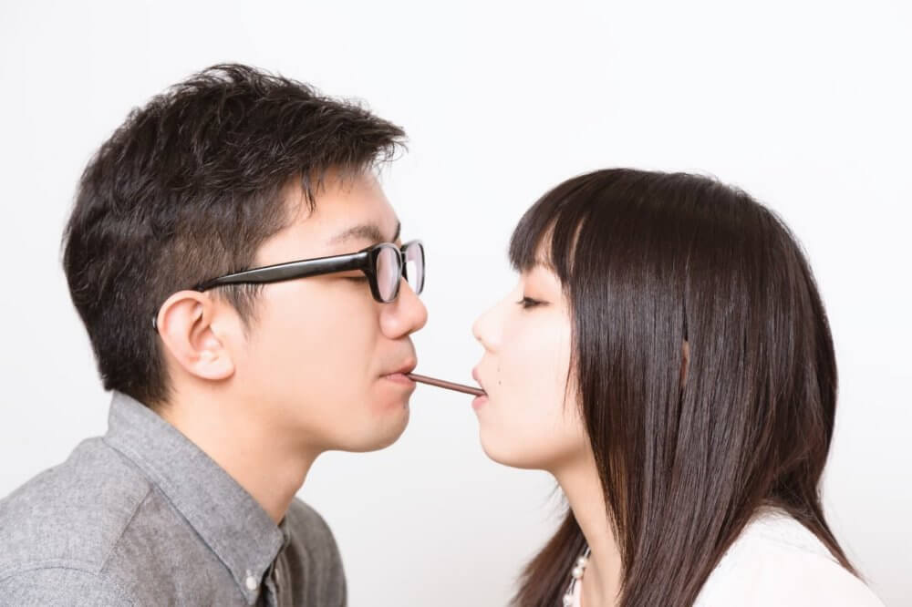 ポッキーゲームに成功する男性と嫌々相手をする女性