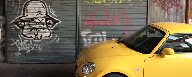 壁の落書きと黄色い車