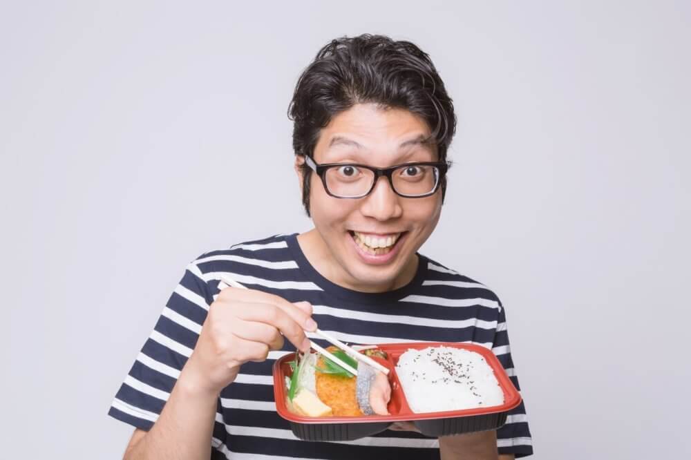 喜んでお弁当を食べる男性