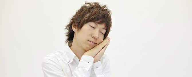 睡眠の仕草をする男性