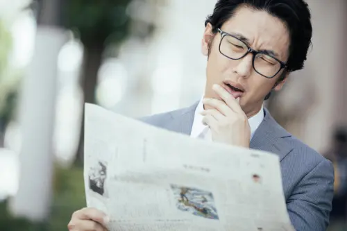 新聞を見て嘆くビジネスマン
