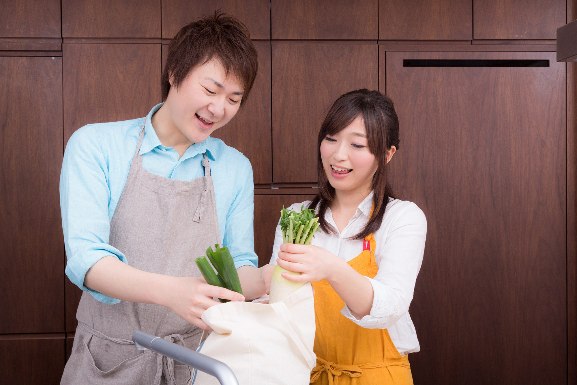 買い物袋から野菜を取り出して料理を始める二人