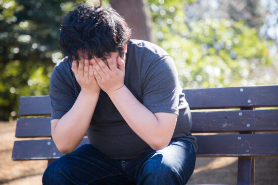 恥ずかしくて顔を抑える男性