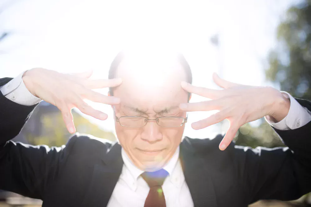 ハゲた頭から強烈な光を発している画像