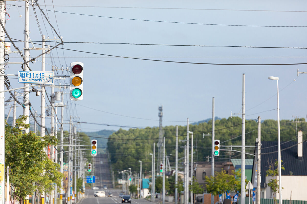 どこまでも続く青信号の信号機が立ち並ぶ道路