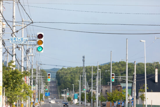 どこまでも続く青信号の信号機が立ち並ぶ道路