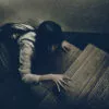 物音を立てないように薄暗い階段を上る女性