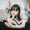 ソファーで寝転んでスマホを見るスマホ女子